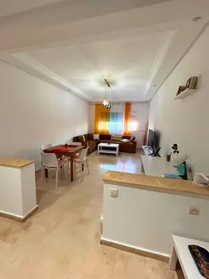 a living room with a table and a couch at Charming apartment near Mohammedia station in Mohammedia