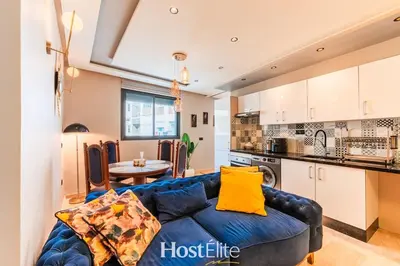a living room with a blue couch and a kitchen at Give Essalam Design & Patio & Clim & 2P in Casablanca