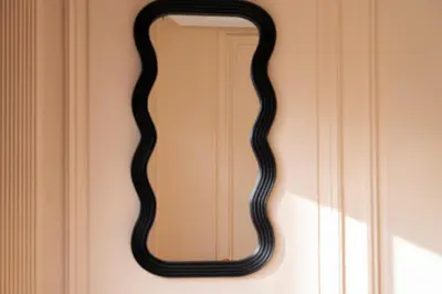 a black snake shaped mirror on a wall at Résidence Terre de Lys in Casablanca