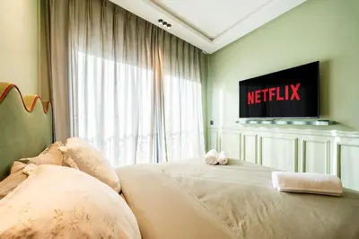 a bedroom with two beds and a television on the wall at Résidence Terre de Lys in Casablanca