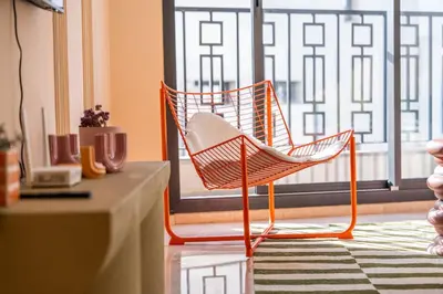 an orange chair sitting in front of a window at Résidence Terre de Lys in Casablanca