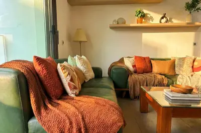 a living room with a green couch with colorful pillows at Maya Suites - Anfa Place - Sea View in Casablanca