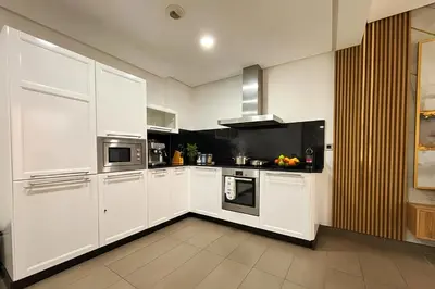 a kitchen with white cabinets and black appliances at Maya Suites - Anfa Place - Sea View in Casablanca