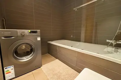a bathroom with a washing machine and a bath tub at Maya Suites - Anfa Place - Sea View in Casablanca
