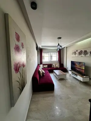 a living room with a red couch and a tv at Appartement centre casablanca in Casablanca