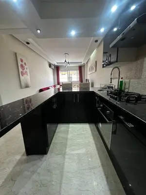 a large kitchen with black counters and a sink at Appartement centre casablanca in Casablanca