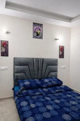 a bedroom with a blue bed with a black headboard at Appart luxe in Rabat