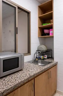 a kitchen with a sink and a microwave on a counter at Appart luxe in Rabat