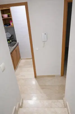 a hallway with a white door and a tile floor at Diamonds in Rabat