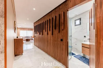 a bathroom with a wooden pivot door with a shower at L'Harmonie in Casablanca