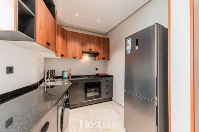 a kitchen with a stainless steel refrigerator and wooden cabinets at L'Harmonie in Casablanca