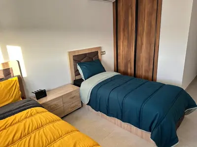a bedroom with a blue bed and a yellow bed at luxury apartment in the city center in Rabat