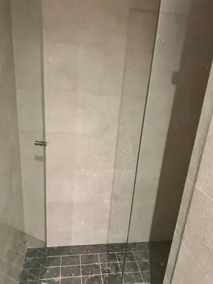 a shower with a glass door in a bathroom at luxury apartment in the city center in Rabat
