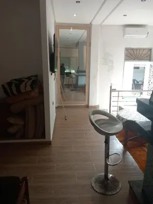a living room with a stool in the middle of a room at Suite in nice résidence in Rabat