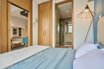 a bedroom with a blue bed and a mirror at Bright Studio at Bliving with Sunny Terrace 1 BR in Casablanca
