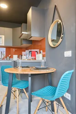 a kitchen with a table and chairs and a mirror at Bright Studio at Bliving with Sunny Terrace 1 BR in Casablanca
