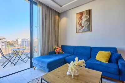 a living room with a blue couch and a table at Sunlit loft with terrace-B living 1 Br in Casablanca