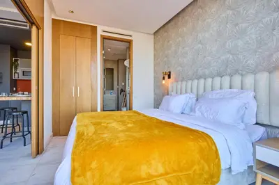 a bedroom with a large bed with a yellow blanket on it at Sunlit loft with terrace-B living 1 Br in Casablanca