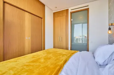 a bedroom with a bed and a sliding glass door at Sunlit loft with terrace-B living 1 Br in Casablanca