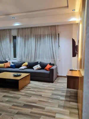 a living room with a blue couch in front of a window at Adnan in Temara