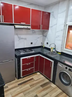 a kitchen with red cabinets and a washing machine at Adnan in Temara