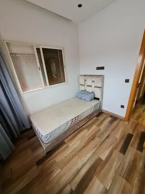 a bedroom with a bed in the corner of a room at Adnan in Temara