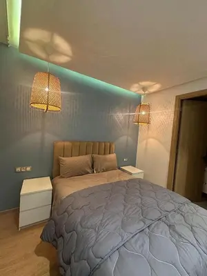 a bedroom with a large bed with two night stands at Anfaflore2 in Casablanca