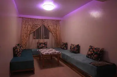 a room with a couch and a table and a window at Modern Apartment in Temara Near Beach & Rabat in Temara