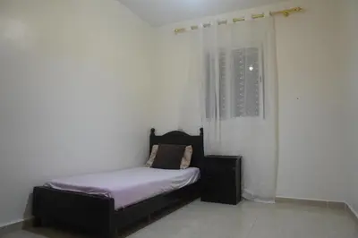 a small bed in a room with a window at Modern Apartment in Temara Near Beach & Rabat in Temara