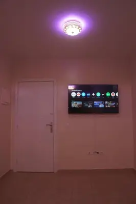 a room with a white door and a tv on the wall at Modern Apartment in Temara Near Beach & Rabat in Temara