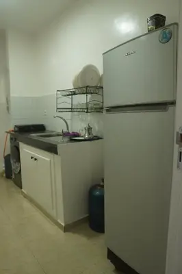 a kitchen with a white refrigerator and a sink at Modern Apartment in Temara Near Beach & Rabat in Temara