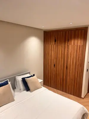a bedroom with a large bed and a wooden cabinet at Apartment for rent in the heart of Casablanca in Maarif