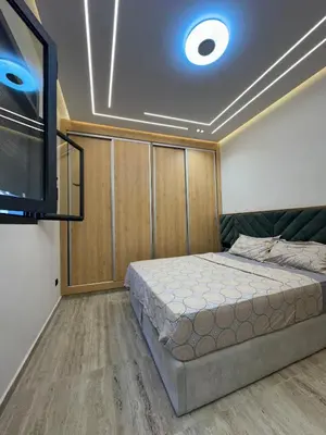 a bedroom with a bed and a flat screen tv at Apartment Témara Ideal Center High Standing in Temara