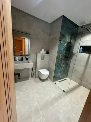 a bathroom with a shower and a toilet and a sink at Apartment Témara Ideal Center High Standing in Temara