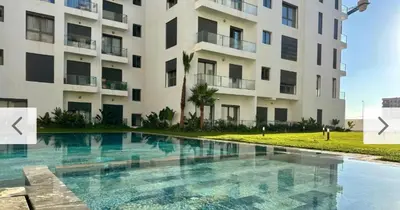 a swimming pool in front of a building at CMN airport apartment in Nouaseur