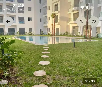 a walkway in the grass next to a swimming pool at CMN airport apartment in Nouaseur