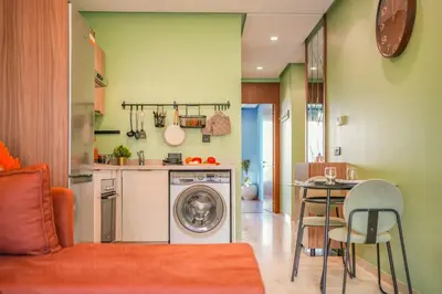 a kitchen with a washing machine and a table with chairs at Premium Stay Near Aeria Mall CFC- Feels like Home in Casablanca
