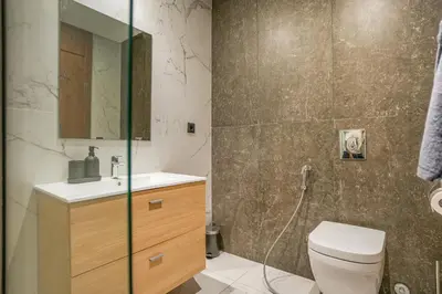 a bathroom with a toilet and a sink and a mirror at Premium Stay Near Aeria Mall CFC- Feels like Home in Casablanca