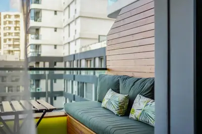 a couch on a balcony with a view of a building at Premium Stay Near Aeria Mall CFC- Feels like Home in Casablanca