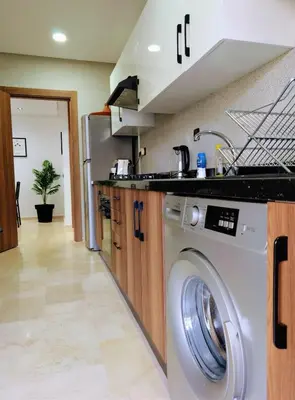 a kitchen with a washer and dryer at Pool view apartment, beach access, nature & quiet in Mansouria