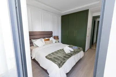 a bedroom with a large bed and green cabinets at Cosy and charming studio - parking & Terasse in Maarif