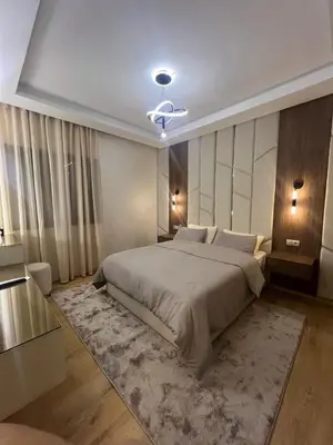 a bedroom with a large bed with a rug at Beautiful appartement with pool and ocean view in Aïn Harrouda