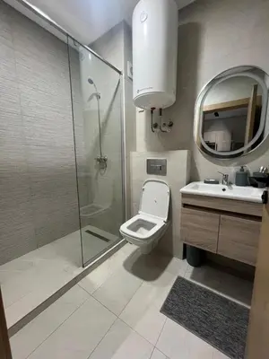 a bathroom with a shower and a toilet and a sink at Beautiful appartement with pool and ocean view in Aïn Harrouda