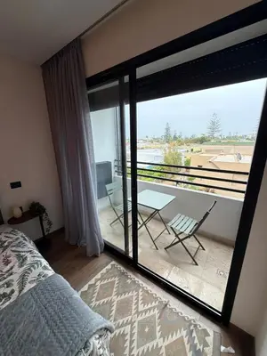 a bedroom with a bed and a balcony with a table at Studio for rent couple in Casablanca