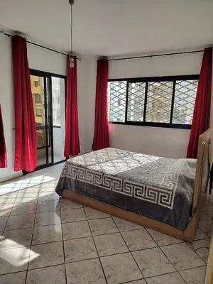 a bedroom with a bed in a room with red curtains at Val Fleurie in Casablanca