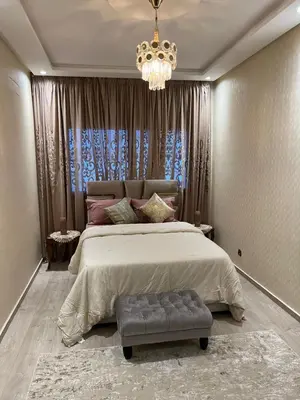 a bedroom with a large bed and a chandelier at Perle de rabat 2 in Rabat
