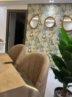 a dining room with two chairs and a wall with mirrors at Perle de rabat 2 in Rabat