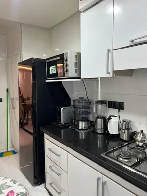 a kitchen with a black counter top and a microwave at Perle de rabat 2 in Rabat