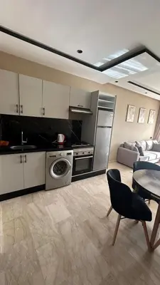 a kitchen and living room with a table and a couch at Studio cosy au coeur de casa - propre et sécurisé in Casablanca