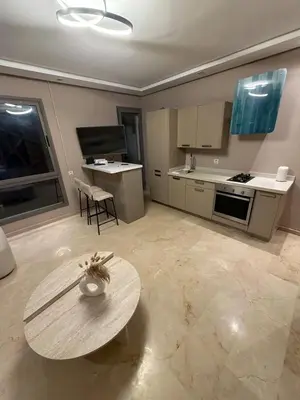 a living room with a table and a kitchen at Nice studio for rent in Casablanca